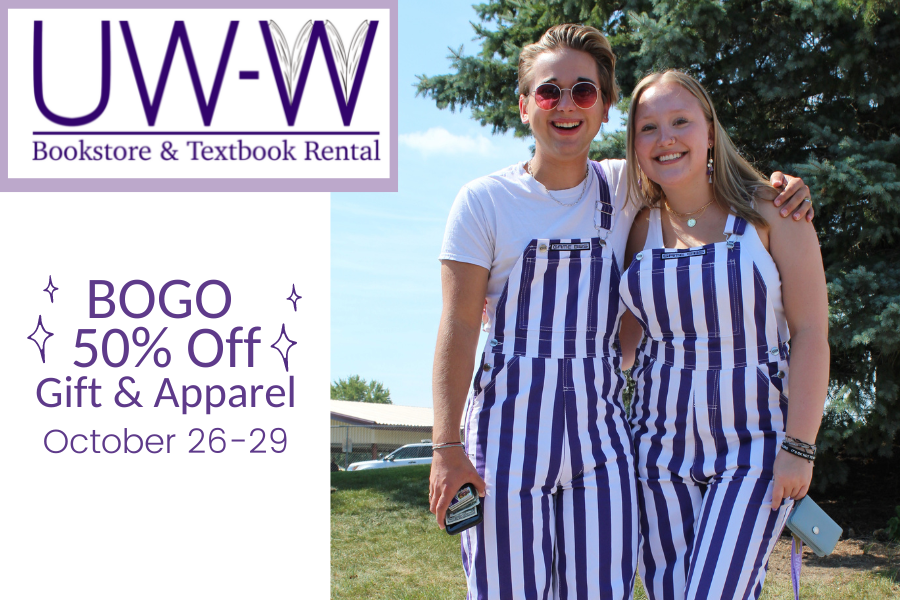 Two students smile and wear purple and white striped overalls.